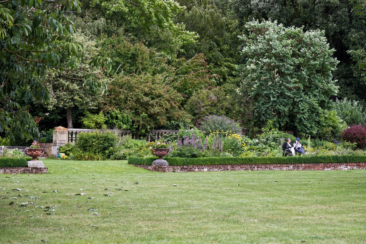 Landscaped garden with planted borders, lawn and mature trees
