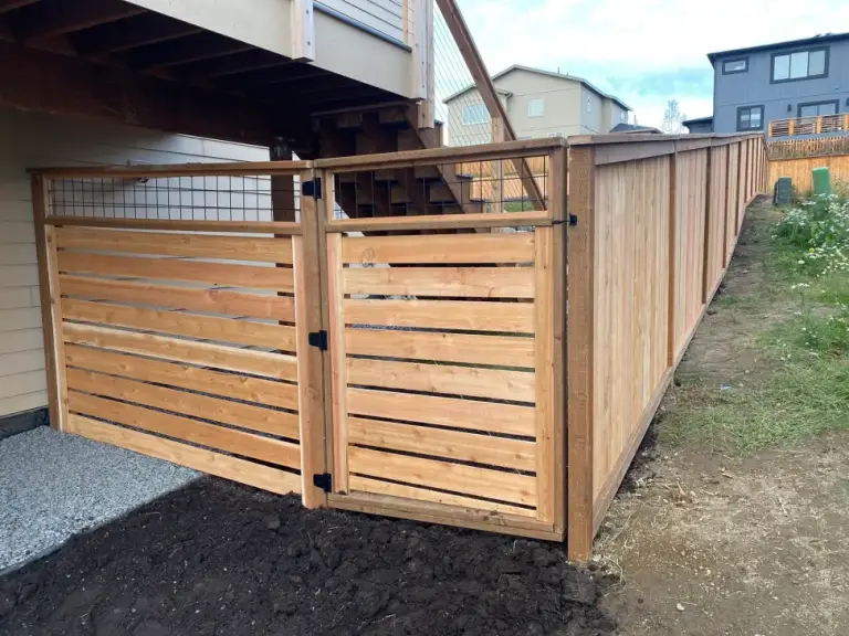 Horizontal slat cedar fence and matching gate built in beneath a deck