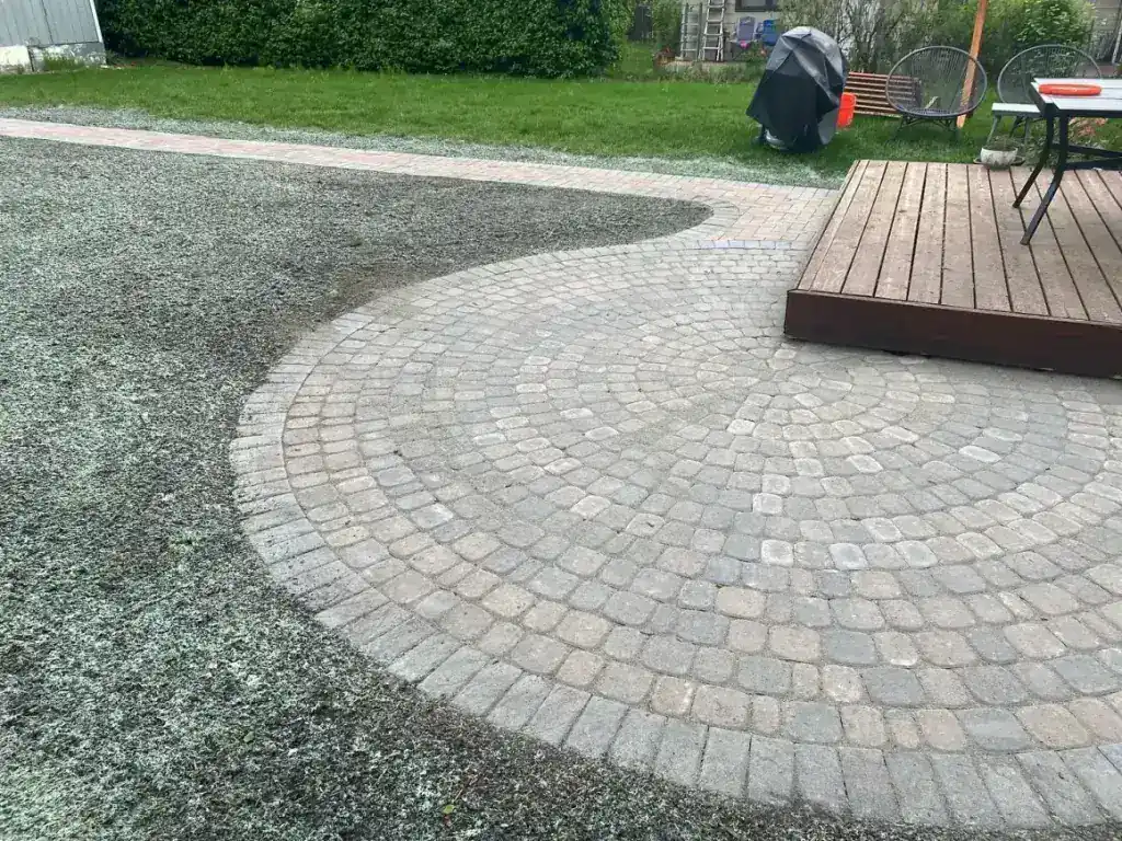 Circular paver patio laid up to the edge of a raised timber deck